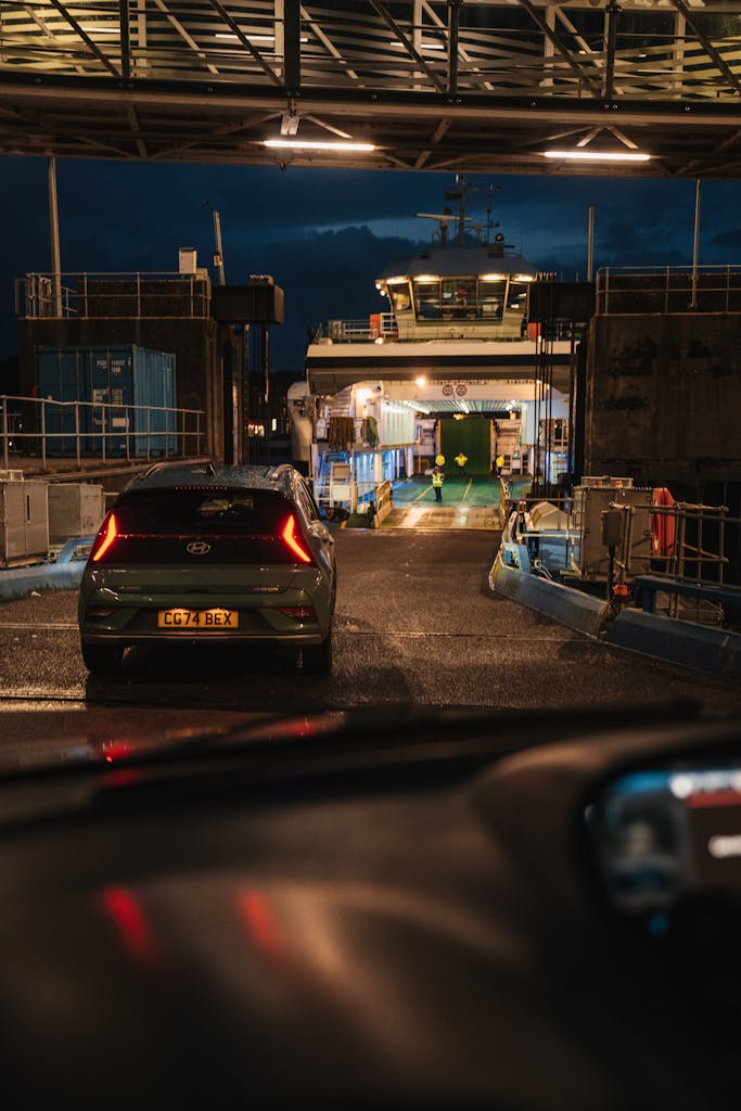 A car boarding a ferry at night in Scotland, showcasing maritime transport.