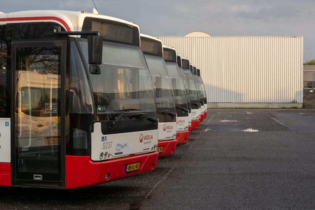 Multiple Veolia buses parked in an urban lot, showcasing public transportation vehicles.